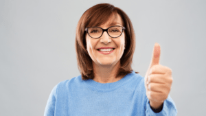 a woman with glasses giving the thumbs up gesture