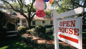 real estate sign advertising an open house with pink and red balloons